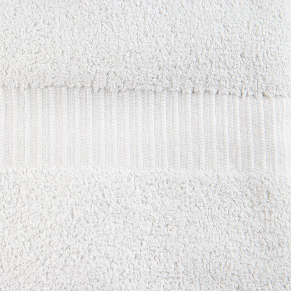 A close up of a white Oxford Belleeza bath towel with a stripe.