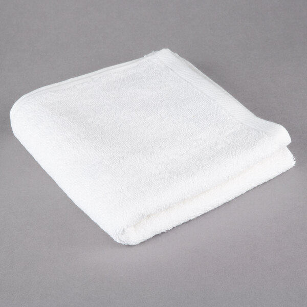 A white Oxford Platinum hand towel with a dobby twill border on a gray surface.
