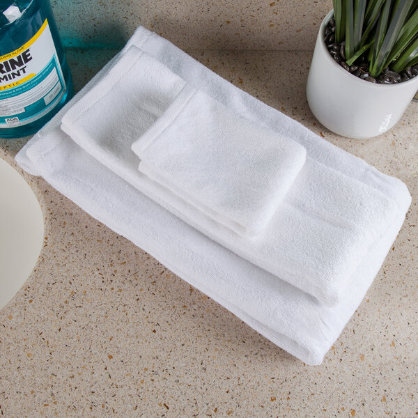 A stack of white Oxford Platinum hand towels on a counter.