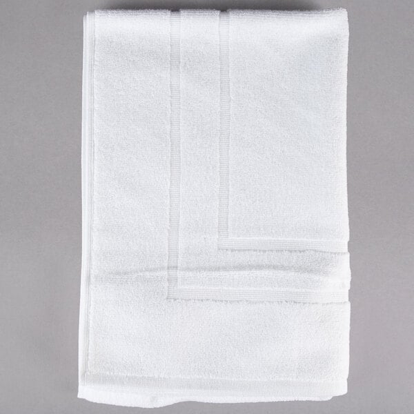 A close-up of an Oxford Platinum white bath mat with a dobby twill hem.