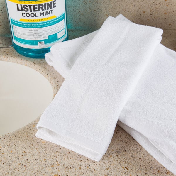 Two white Oxford Platinum hand towels on a counter.