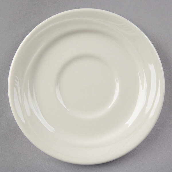 A Oneida cream white china saucer with a circular edge.