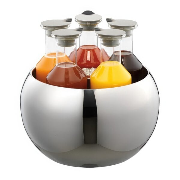 A stainless steel bowl with four Frilich stainless steel carafes filled with different colored liquids.