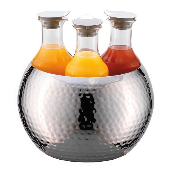 A group of Frilich stainless steel carafes holding juice in a metal bowl.