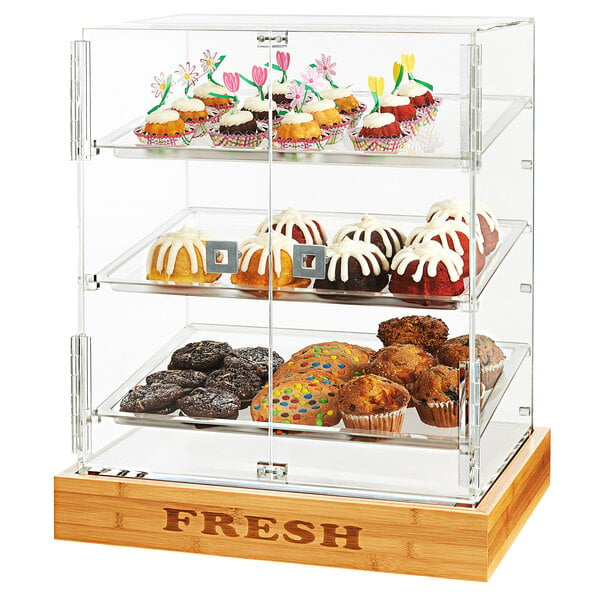 A Rosseto bakery display case with a glass door and bamboo shelves holding frosted pastries.