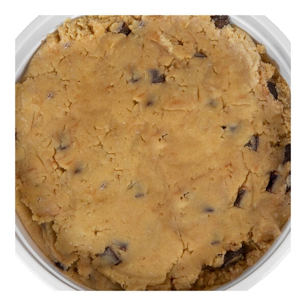 A close-up view of chocolate chunk cookie dough in a round container.