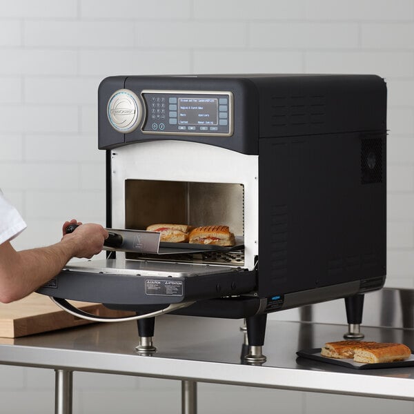 Putting a panini in a black TurboChef high speed oven