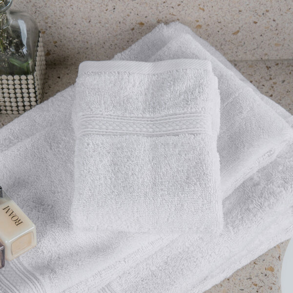 A stack of Oxford Vicenza Bianco white wash cloths on a white counter.