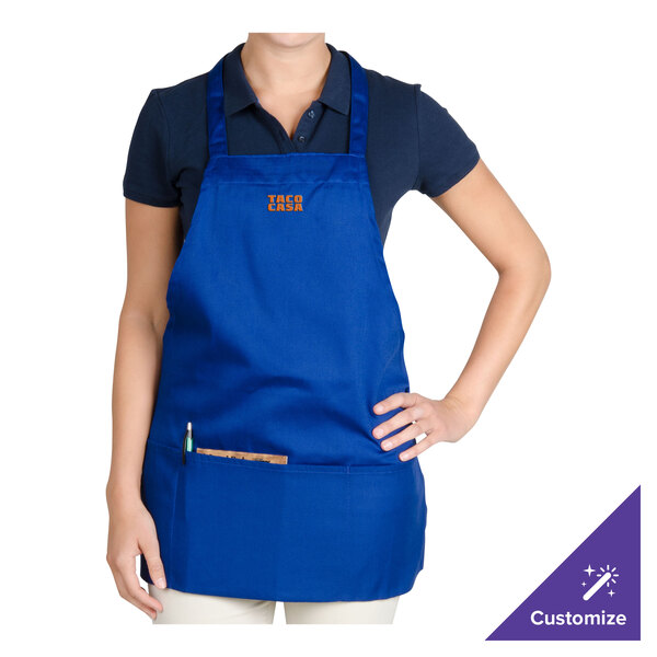 A woman wearing a royal blue Chef Revival apron with a pocket.