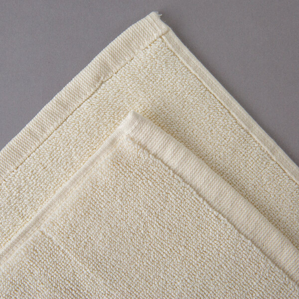 An Oxford Vicenza Avorio white bath mat with a folded edge.