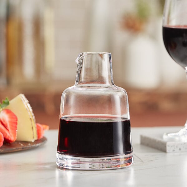 An American Metalcraft glass carafe filled with a dark liquid next to a glass of the same liquid.