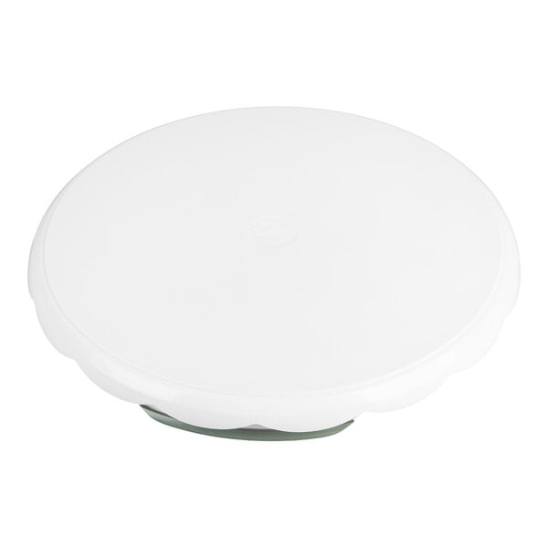 A white, round, plastic turntable with a scalloped edge, viewed from above.