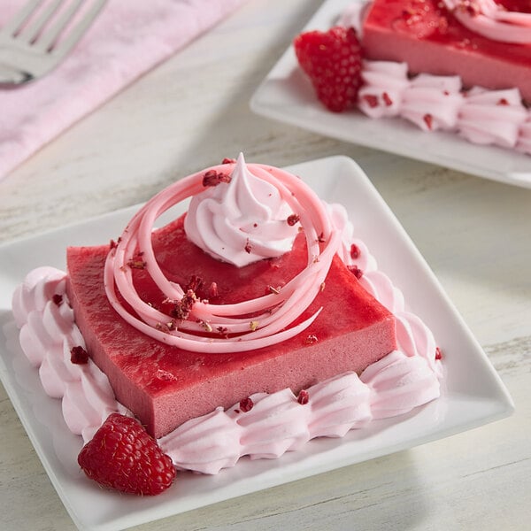 A square pink dessert with Monin Raspberry Concentrated Flavor, whipped cream, and raspberries.
