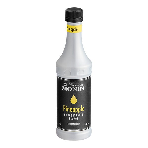 A white Monin bottle of concentrated pineapple flavor with a black label.