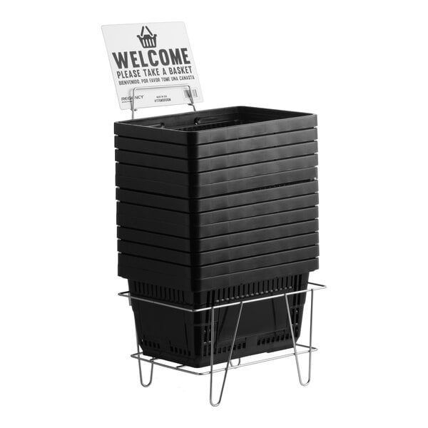 A stack of black plastic grocery shopping baskets with a metal stand and a welcome sign.