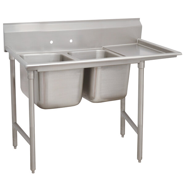 An Advance Tabco stainless steel sink with two compartments and a right drainboard.