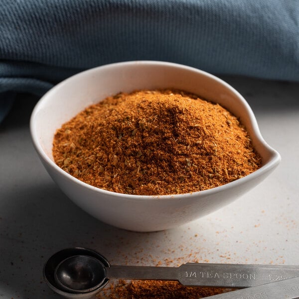 A bowl of McCormick Cajun Seasoning and a measuring spoon.
