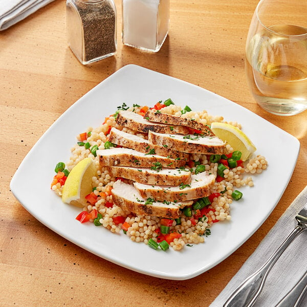 A plate of food with chicken and vegetables on a white Acopa porcelain plate.