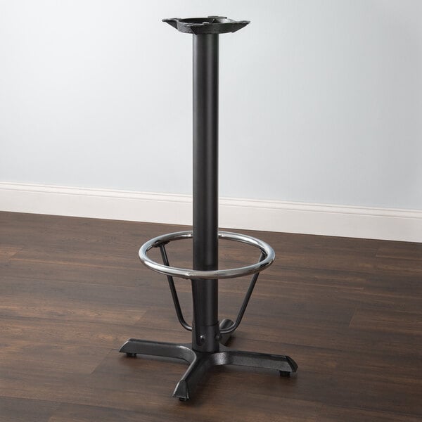 A Lancaster Table & Seating black cast iron bar height column table base with a metal foot ring.