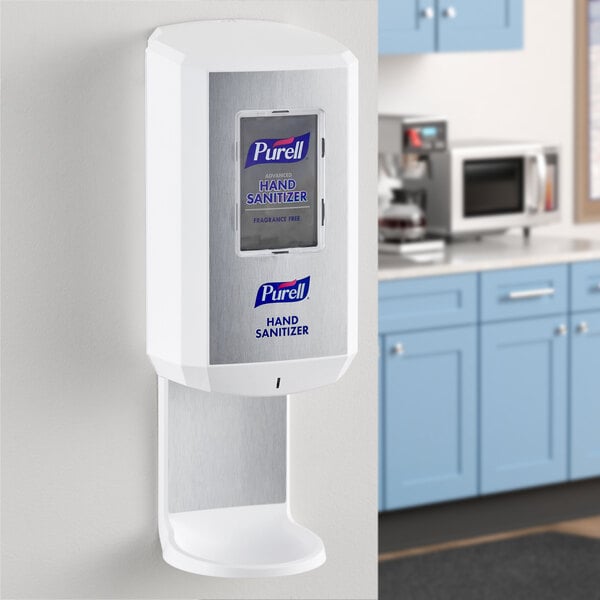 A white Purell automatic hand sanitizer dispenser on a kitchen counter.