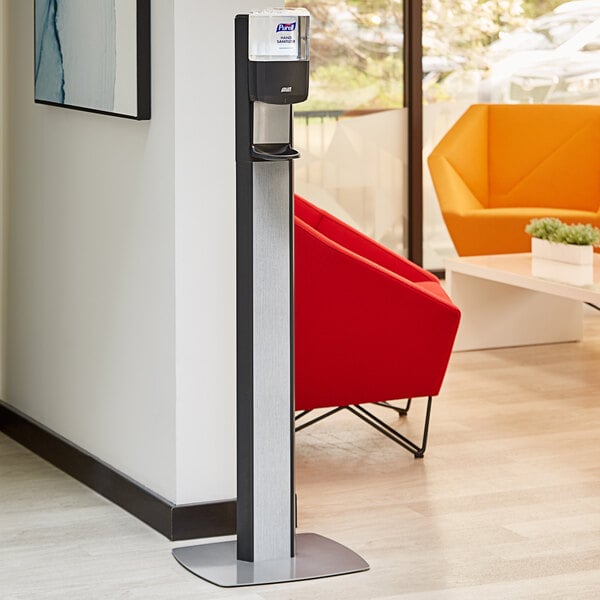 A Purell Messenger ES6 automatic hand sanitizer dispenser with a graphite panel floor stand in a corporate office cafeteria.