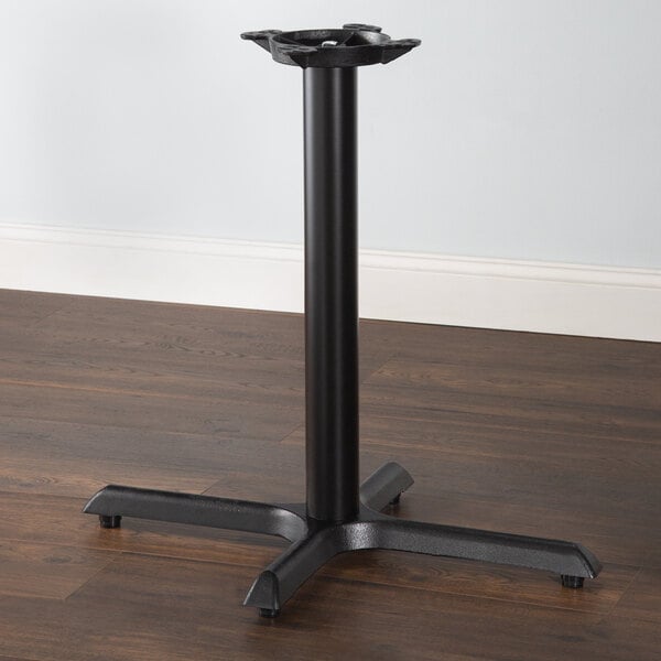 Black steel cross table base on wood floor