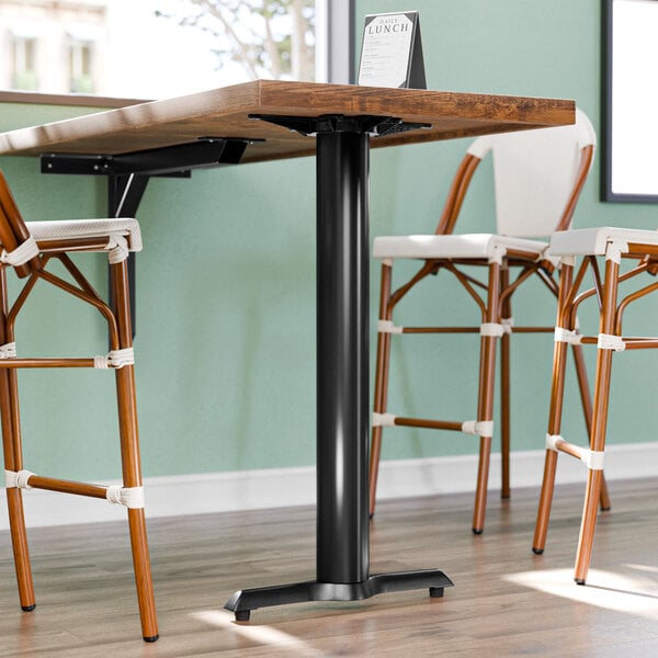 A Lancaster Table & Seating black bar height end column table base with chairs.