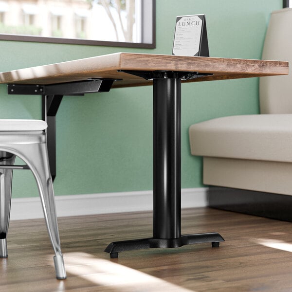 A Lancaster Table & Seating black cast iron end table base with self-leveling feet.