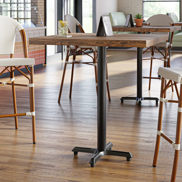 A Lancaster Table & Seating black cast iron bar height table base with a black pole.