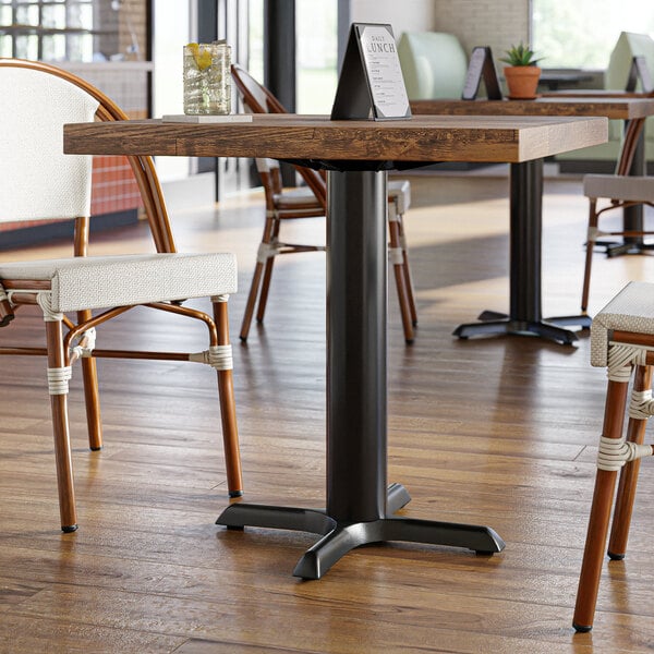 A Lancaster Table & Seating black cast iron table base on a table in a restaurant.