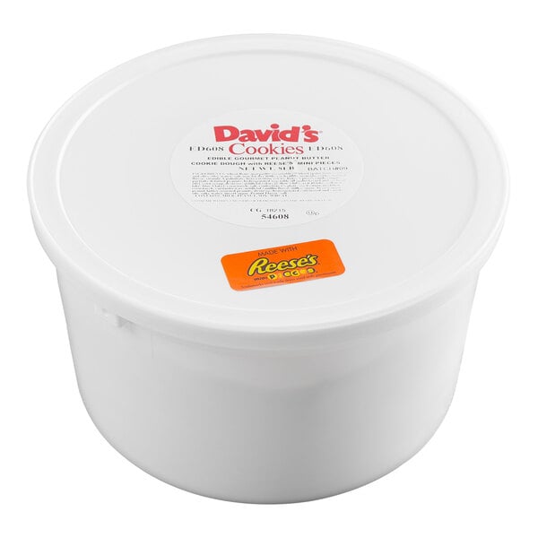 A large white plastic tub with a lid featuring labels for David's Cookies and Reese's, indicating it contains cookie dough.