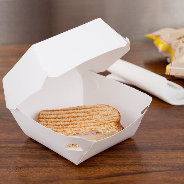 A sandwich in a Microwavable Hinged White Paper Take Out container.