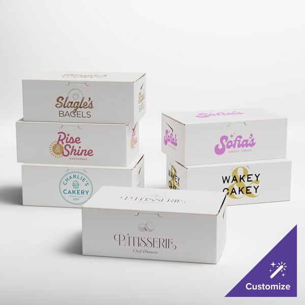 A group of white customizable cake boxes with different colored text.