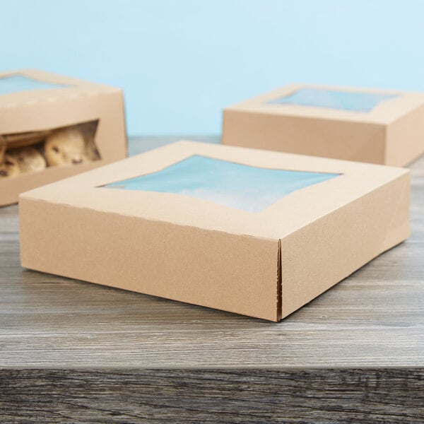 A brown kraft bakery box with a clear window on top, designed for packaging pies or baked goods.