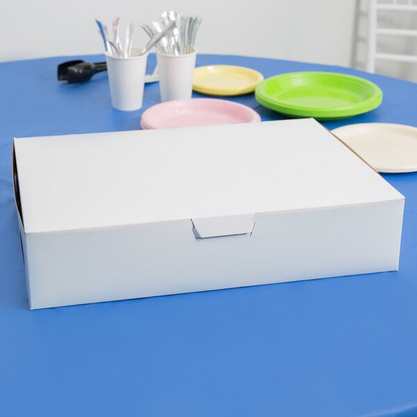 A white box on a blue table with a lid.