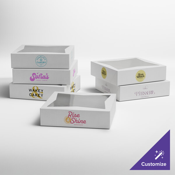 A set of white customizable auto-popup bakery boxes with clear window tops, each featuring different printed logos.