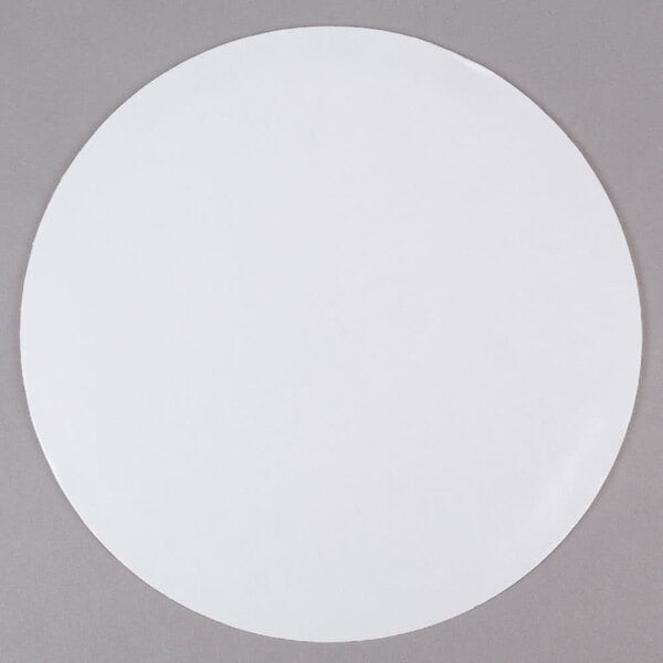 A 16" white corrugated cake circle on a gray surface.