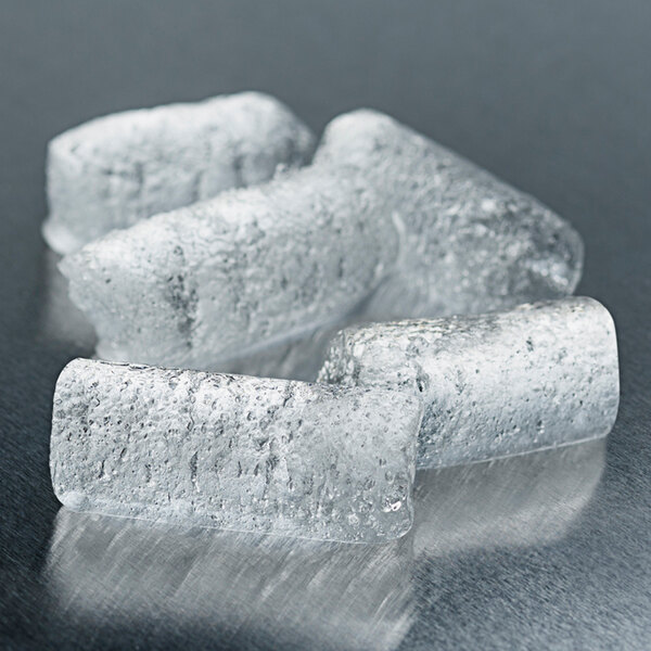 A group of cylindrical chewable ice pieces on a reflective surface.