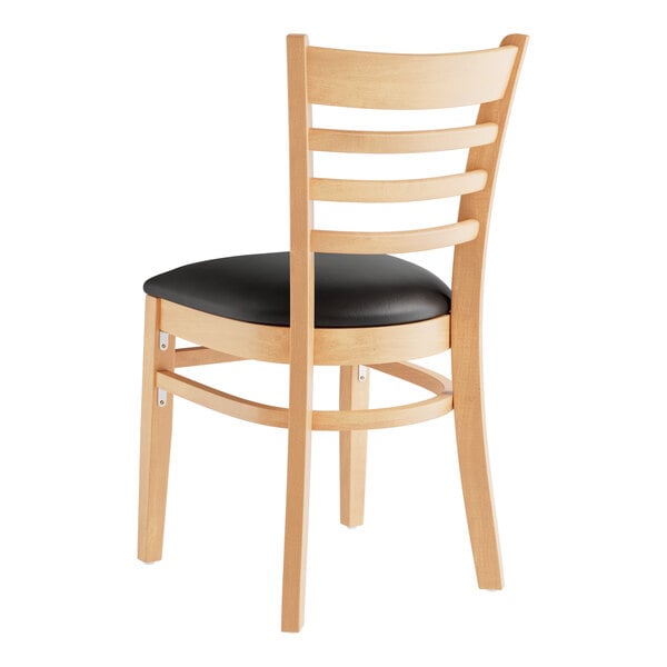 A Lancaster Table & Seating wooden restaurant chair with a black vinyl seat and ladder back.
