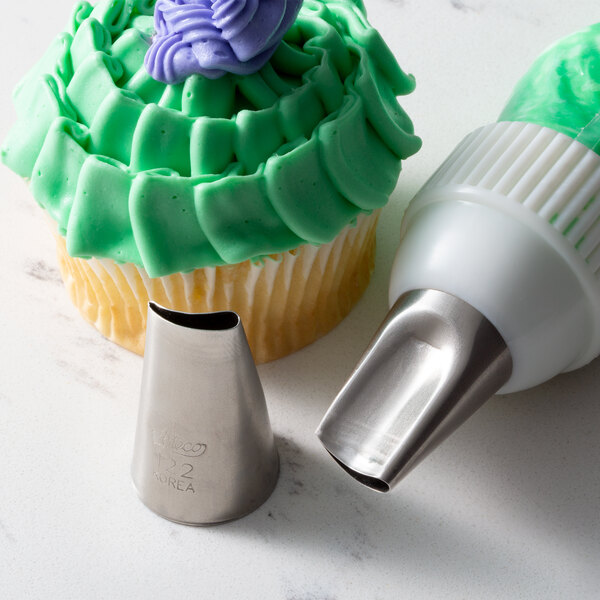 A cupcake with green frosting piped with an Ateco curved petal nozzle.