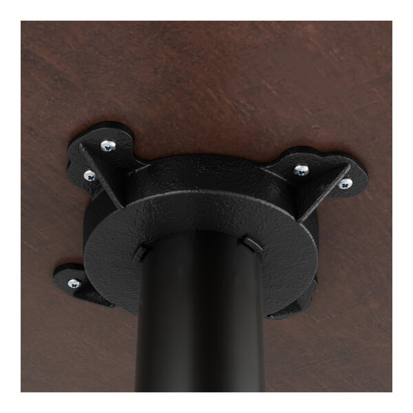 A black Lancaster Table & Seating cast iron bar height table base with metal bolts.