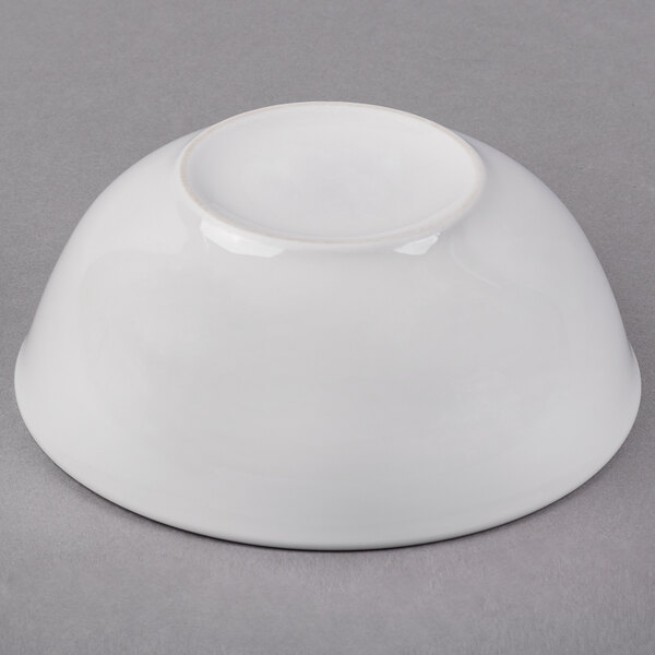 A Libbey Lunar Bright White porcelain cereal bowl on a gray surface.