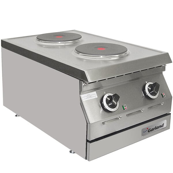 A close-up of a Garland stainless steel countertop hot plate with two solid burners.