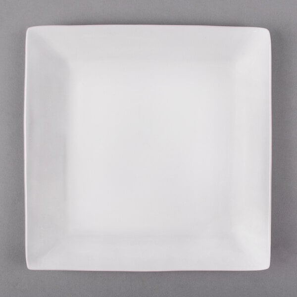 A white Libbey square porcelain plate with a white rim on a gray surface.