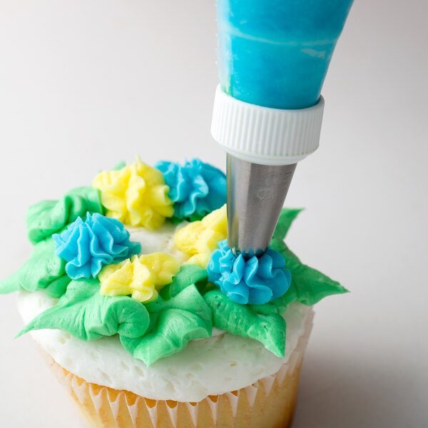 A cupcake with yellow and blue piped flowers on top.