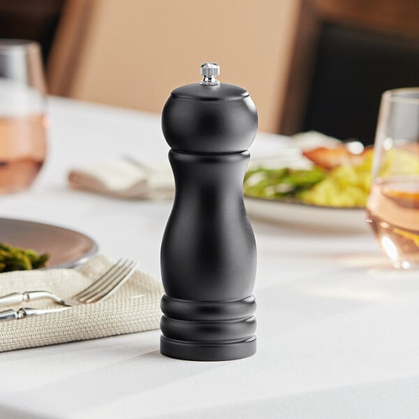 A black Acopa wooden salt/pepper mill on a table.