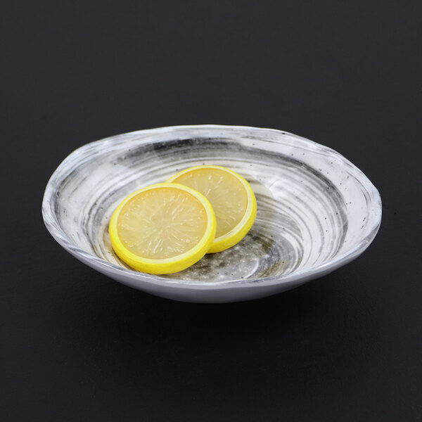 An Elite Global Solutions Van Gogh black melamine oval bowl with lemon slices in it.