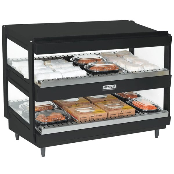 A black Nemco countertop double shelf food warmer with trays of food on it.