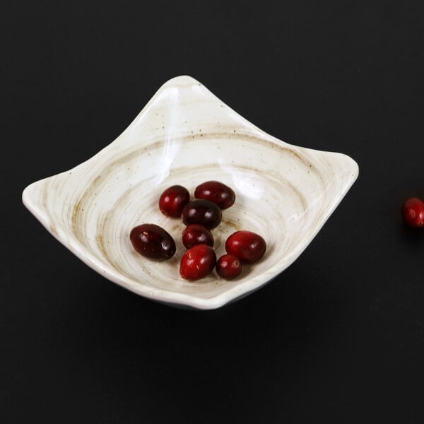 An Elite Global Solutions square taupe melamine bowl with red berries in it.