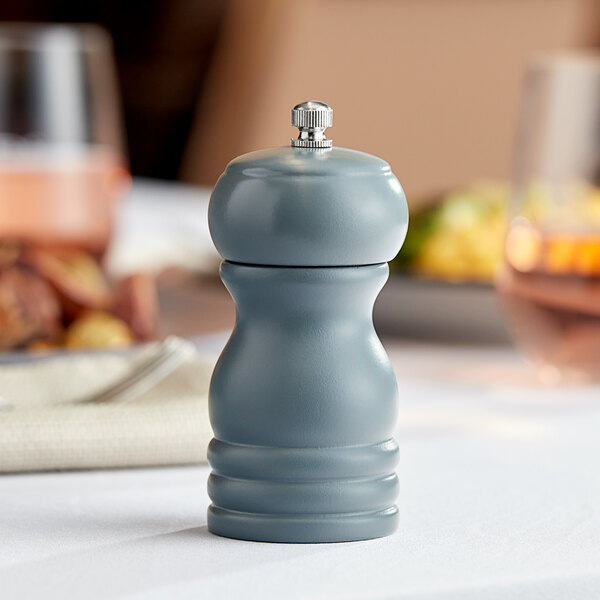 An Acopa steel blue wooden pepper mill on a table.